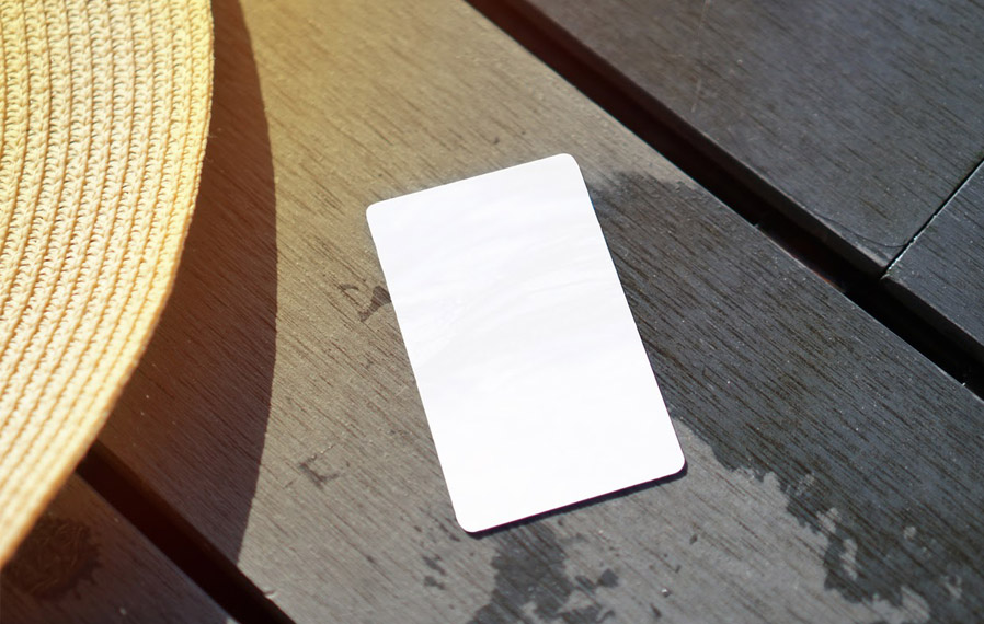 Don't forget your pool pass to to take a refreshing swim at The Hamilton Luxury Apartment Homes. Summer hat and key card on a deck floor.